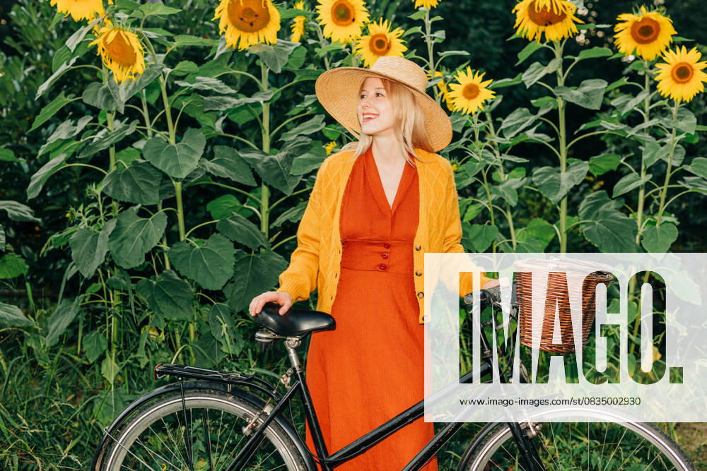 Vintage style woman outdoors with bicycle in sunflower garden model released, Symbolfoto, VSNF04142