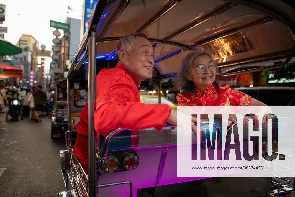Ein glückliches älteres Paar in einem Chinatown in Bangkok, Thailand, A happy senior couple in a Chinatown in Bangkok, Thailand, using a local small car to explore the sights together, enjoying the city s transportation and lifestyle (License=RF) ,model released, Symbolfoto