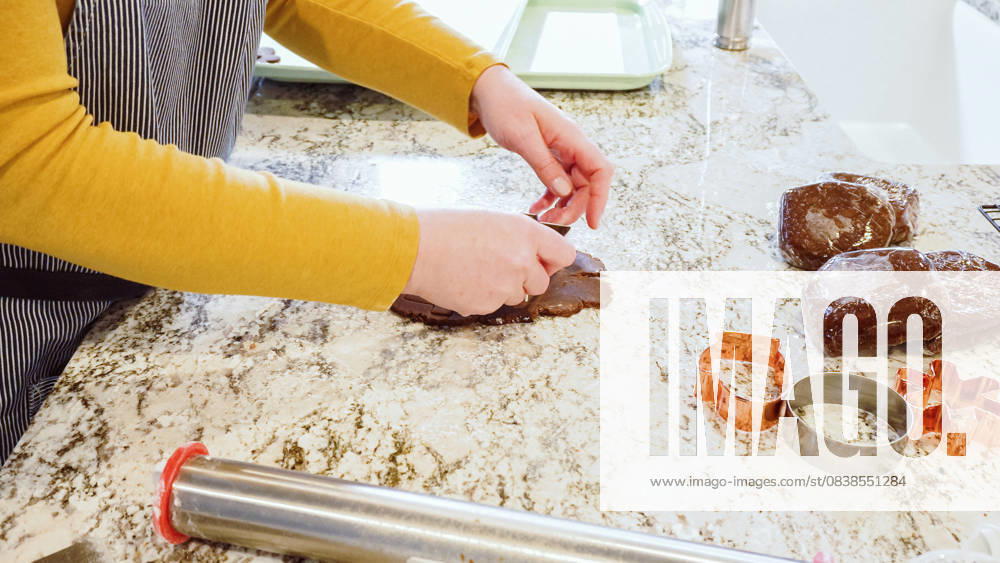 IMAGO Creative, Weihnachten, Food, Backen, Lebkuchen Baking Christmas Gingerbread Cookies in a Modern Kitchen Using various festive cookie cutters, we re cutting out charming gingerbread cookies from the rolled dough on the sleek marble counter, bringing holiday cheer to the modern kitchen., 61071452.jpg RECORD DATE NOT STATED