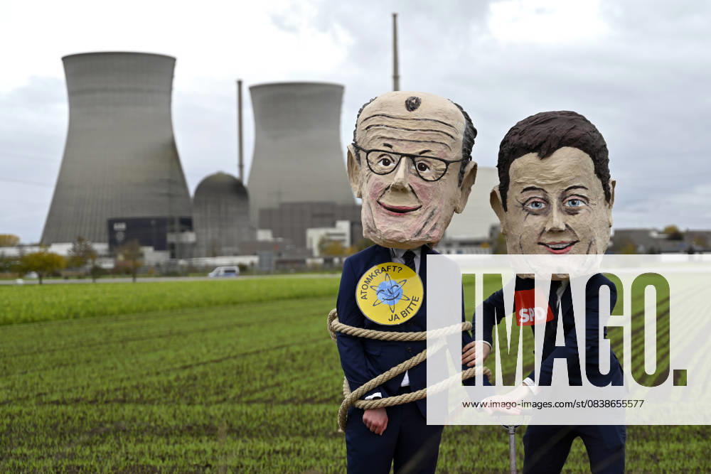 The cooling towers of the nuclear power plant in Gundremmingen before the demolition Demonstrators wearing masks of Federal Chancellor Friedrich Merz CDU and politician Lars Klingbeil SPD pose an