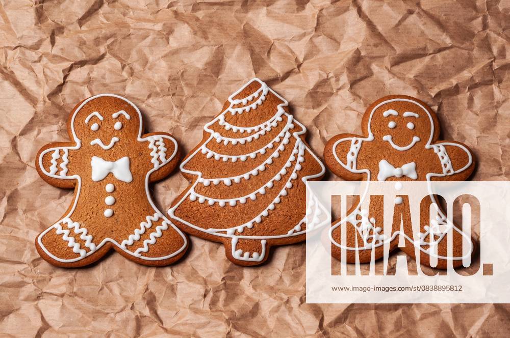 IMAGO Creative, Weihnachten, Food, Backen, Lebkuchen Festliche Pfefferkuchen auf braunem Papier für die Feiertage Delicious gingerbread men and a Christmas tree cookie are arranged on textured brown paper, perfect for the holiday season (License=RF)