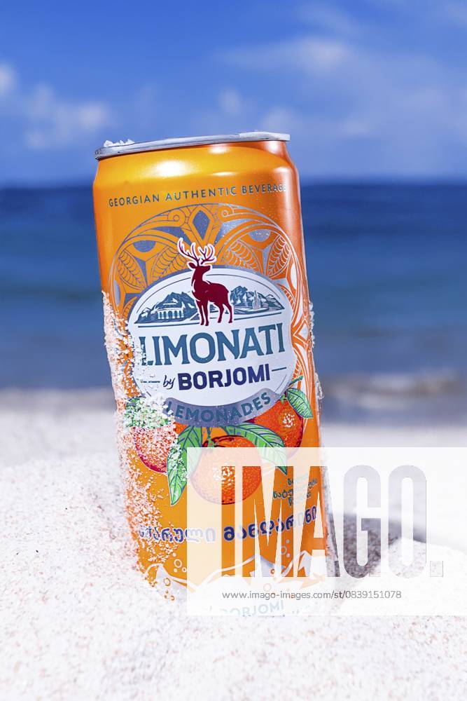 Adjara Mandarinenlimonade, Borjomi, Aluminiumdose, auf dem Strandsand, vor dem Hintergrund des Meeres, Sonnenlicht, Nahaufnahme Adjara mandarin lemonade, Borjomi, aluminum can, on the beach sand, against the background of the sea, sunlight, close-up