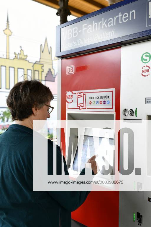 Elderly woman buys ticket at ticket machine VBB Verkehrsverbund Berlin Brandenburg S station Savigny Platz in the background mural silhouette of Berlin Berlin Germany Berlin