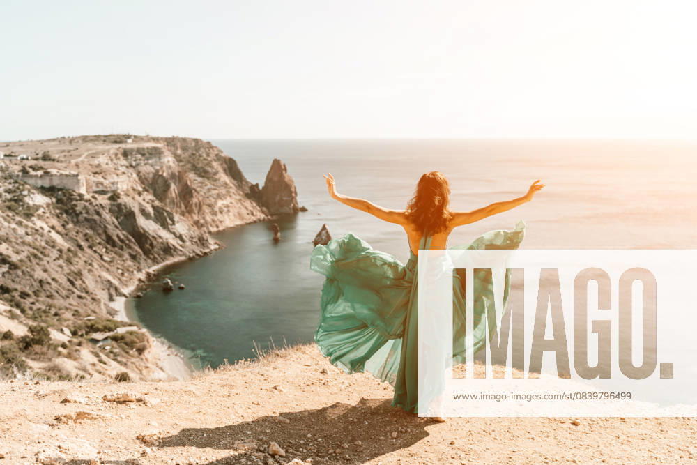 Woman green dress sea. Female dancer posing on a rocky outcrop high above the sea. Girl on the nature on blue sky background. Fashion photo. Woman green dress sea. Female dancer posing on a rocky outcrop high above the sea. Girl on the nature on blue sky background. Fashion photo, model released, , 61782316.jpg RECORD DATE NOT STATED