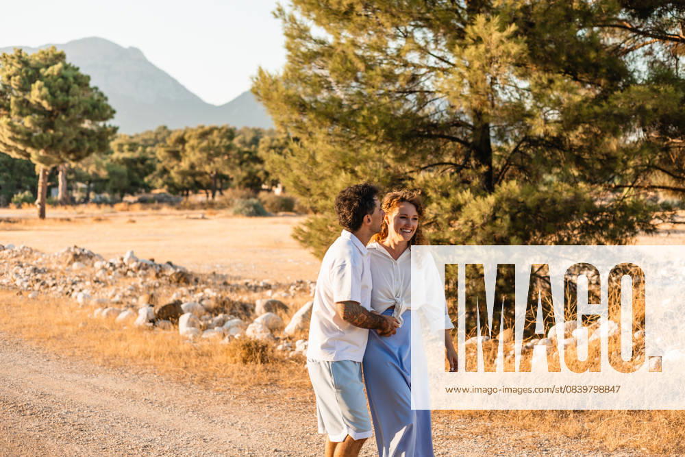 Romantic couple walking in Turkish countryside A happy couple enjoys a warm day walking through the stunning Turkish countryside, surrounded by trees and mountains, capturing the essence of love and nature together. Model Released AlinaKandybka_ID32198_1096356_017