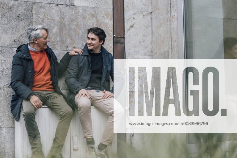 Confident senior man and young man sitting in the city talking model released Symbolfoto GUSF00642