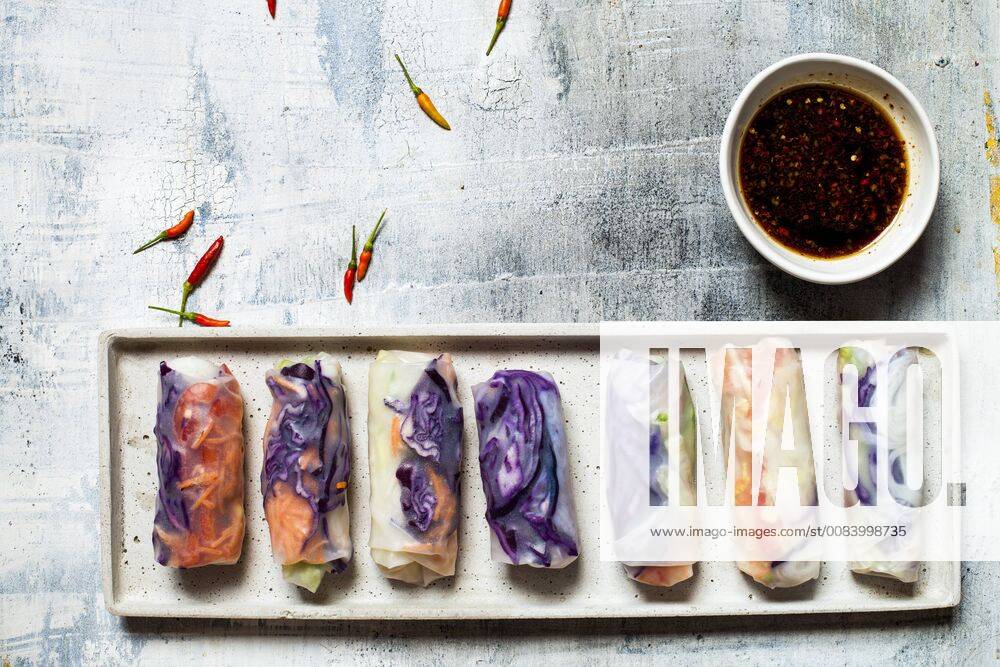 Vegan rice paper wraps (vietnamese summer rolls), filled with cabbage, carrots, bell pepper, rice noodles, and dipping sauce SBDF03575