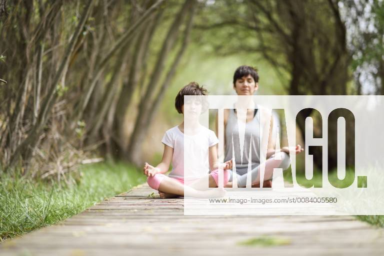 Mother and daughter doing yoga on boardwalk model released Symbolfoto JSMF00188
