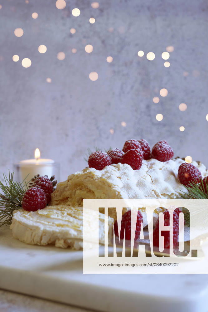 Christmas Buche de Noel White Yule Log Cake with Bokeh Lights on White Marble Board. Christmas Buche de Noel White Yule Log Cake with Bokeh Lights on White Marble Board.