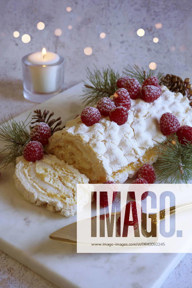 Christmas Buche de Noel White Yule Log Cake with Bokeh Lights on White Marble Board. Christmas Buche de Noel White Yule Log Cake with Bokeh Lights on White Marble Board.