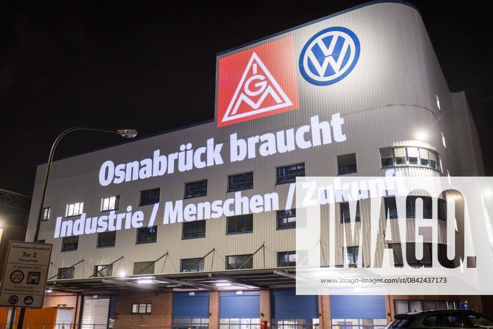 Projection of IG Metall logo and lettering Osnabrück needs industry people future next to the VW logo on the facade of the Osnabrück VW plant Peaceful protest rally of IG Metall in Osnabrück with on the situation automotive industry VW plant Osnabrück 08 12 2025 IG Metall rally in front of the VW plant Osnabrück