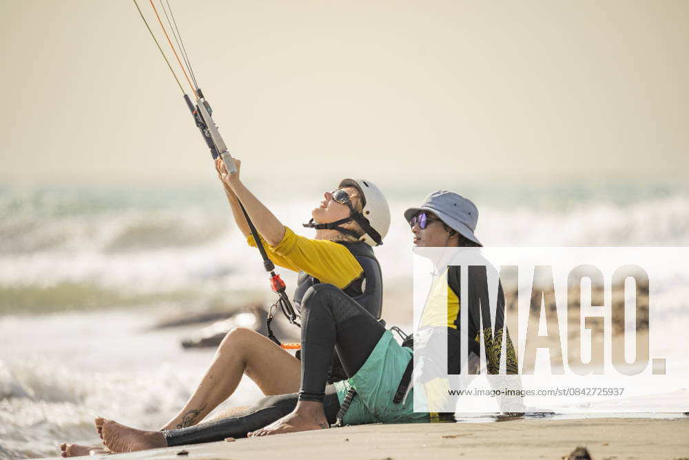 MR_ID31343_22933_DarioImitola.jpg, MR_ID31343_22932_SoniaFenoglio.jpg Student and instructor sit on the sandy shore of Salinas del Rey, Atlantico, Colombia, during a kitesurf lesson. The instructor guides the student as they prepare to catch the waves. Model Released VictorCuenca_ID31343_1065775_004