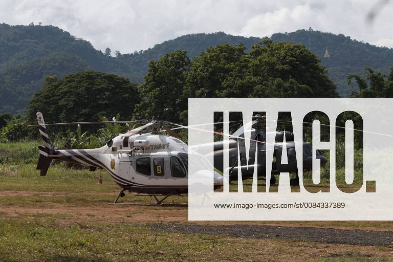 Mae Sai, Chiang Rai, Thailand - A Royal Thai Police helicopter and Royal Thai Navy helicopter wait in a field near the Tham Luang cave to evacuate the reamaining 9 trapped soccer team members. Mae Sai Thailand - ZUMAogra 20180709_mda_t128_059