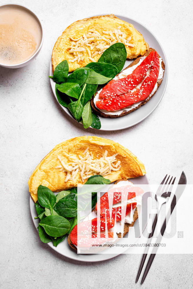 IMAGO Creative, Food, High Protein Frühstück Gesundes Frühstück. Omelett, Sandwich mit Lachs, Spinat. Healthy balanced breakfast for two. Omelette, spinach, wholegrain sandwich with cream cheese and salmon fish. Breakfast together, top view. (License=RF)