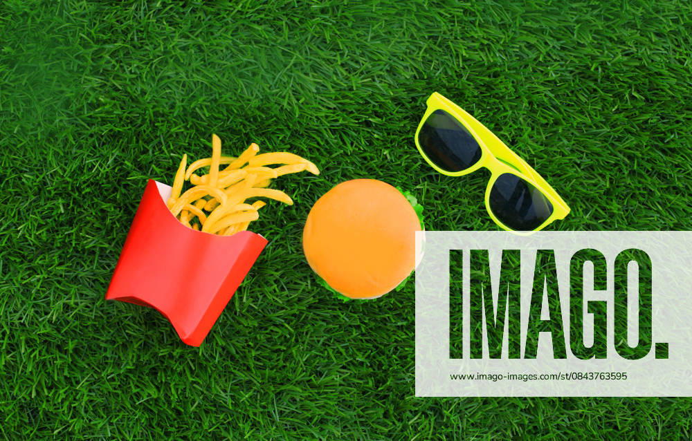 Fast food concept - burger, french fries and sunglasses on the grass background Fast food concept - burger, french fries and sunglasses on the grass background, 62171698.jpg RECORD DATE NOT STATED