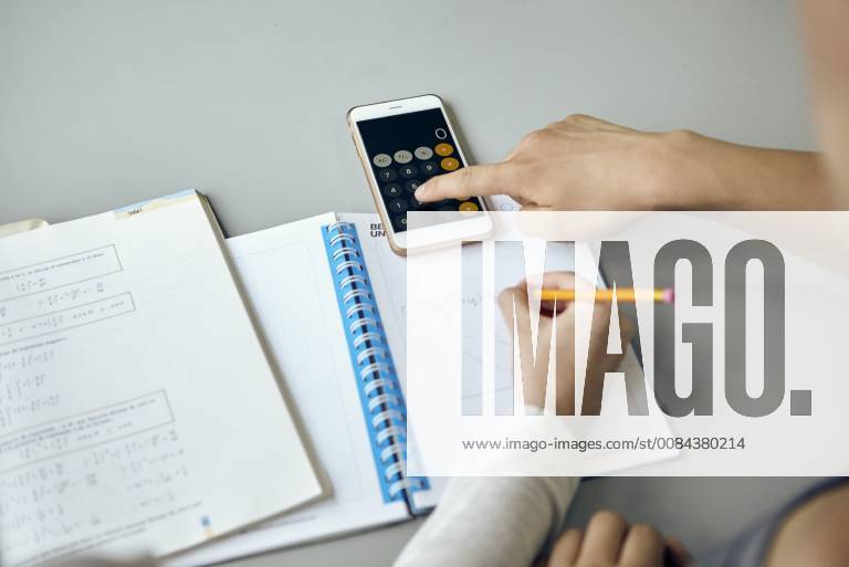 Students using smartphone calculator function while completing math assignment