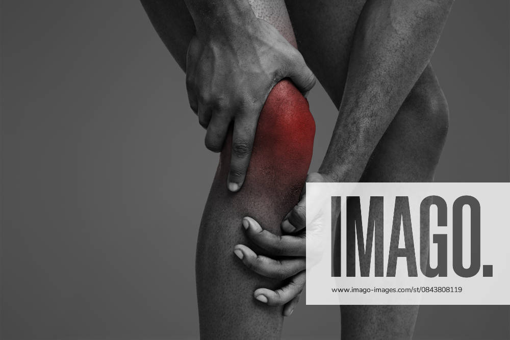 Young man massaging his painful knee, close up Trauma, stretching. Cropped of black man massaging his sore injured knee, white background, model released, , 62283580.jpg RECORD DATE NOT STATED