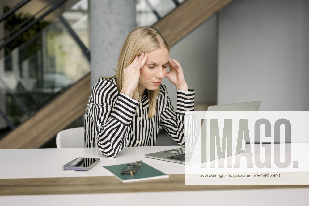 Stressed businesswoman working on laptop at modern office desk model released, Symbolfoto property released, FLMZF01870