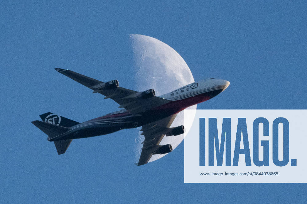 A cargo plane flies in front of the moon at sunset in Frankfurt, Germany. Frankfurt Germany - ZUMAb332 20251227_zip_b332_009