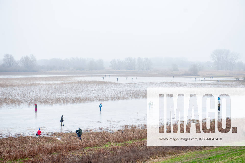 A view of the skater from the top of the dike. After several days of sub-zero temperatures during the night, the water of some lakes started to freeze over. People took the chance to skate on one of the frozen lakes close to the Dutch city of Nijmegen. It takes at least four whole days of below-freezing temperatures to form ice thats safe to walk and skate on, and that only applies to ponds or lakes with no currents. Nijmegen Netherlands - ZUMAs197 20251227_aab_s197_060
