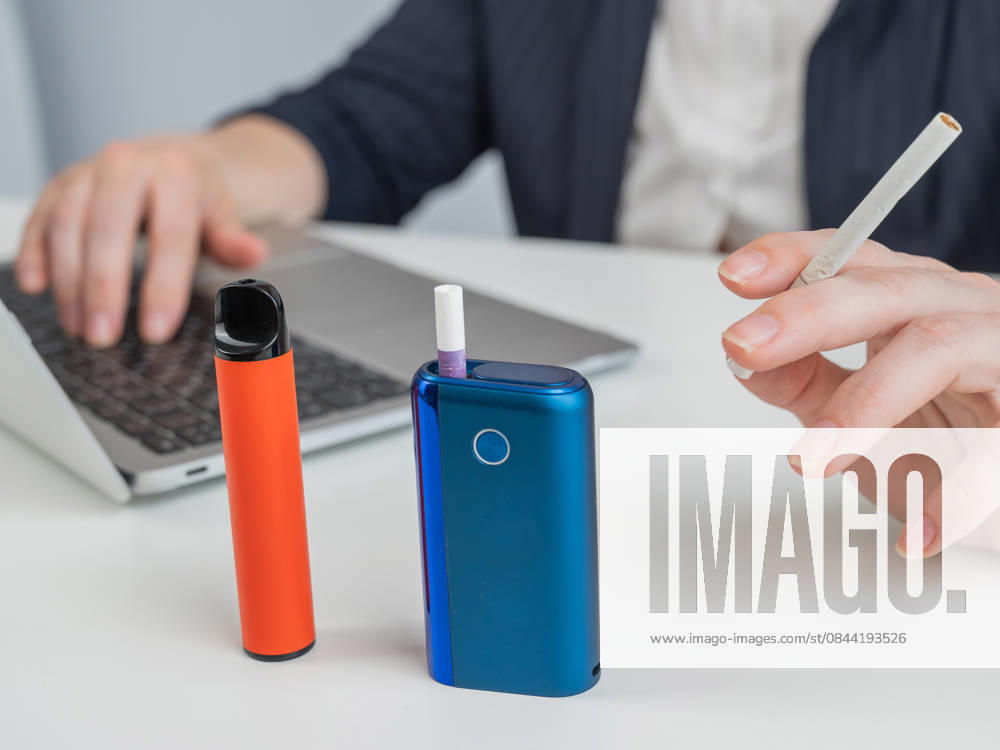 A woman demonstrates different types of cigarettes. An e-cigarette, a disposable vape, and a regular cigarette. A woman demonstrates different types of cigarettes. An e-cigarette, a disposable vape, and a regular cigarette, model released, , 97688556.jpg RECORD DATE NOT STATED