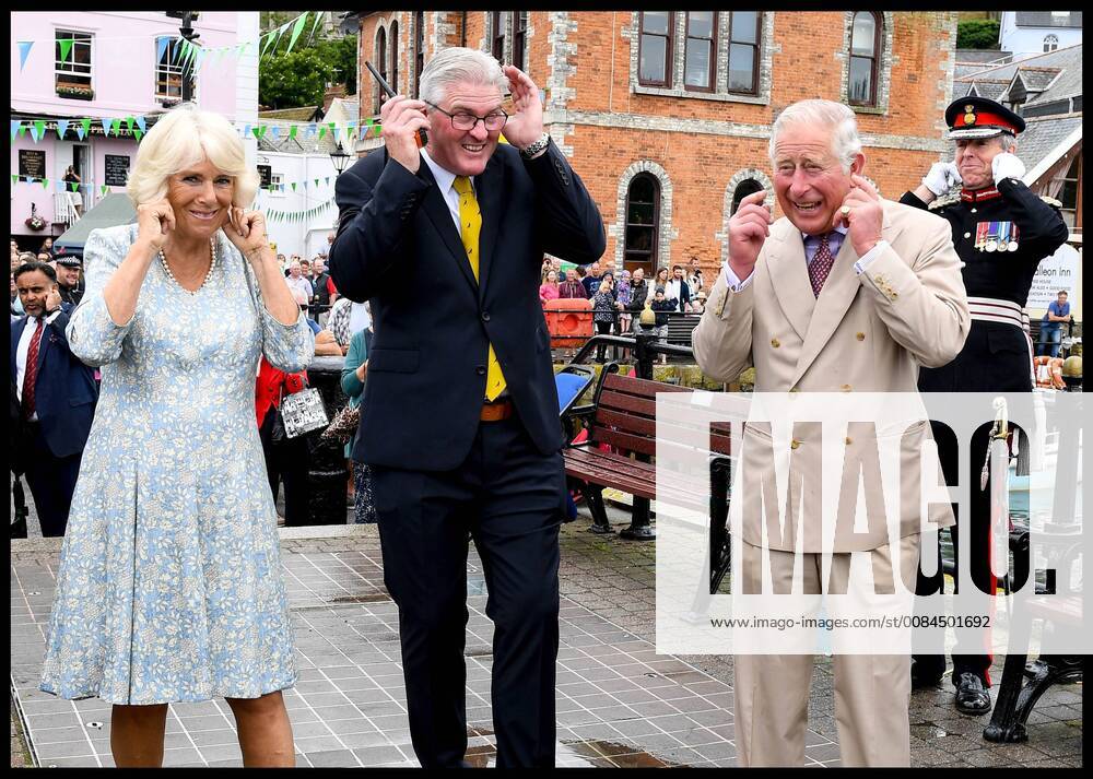 . 16 07 2018. Fowey, United Kingdom. Prince Charles the Duchess of Cornwall visit Cornwall. The Duke and Duchess of Cornwall put their fingers in their ears as the cannon gun is fired to launch the gig race as they visit the celebration of Fowey festival meeting local businesses, representatives from Fowey gig club and members of the RNLI on Fowey Quay. xAndrewxParsonsx xi-Imagesx IIM-18220-0024