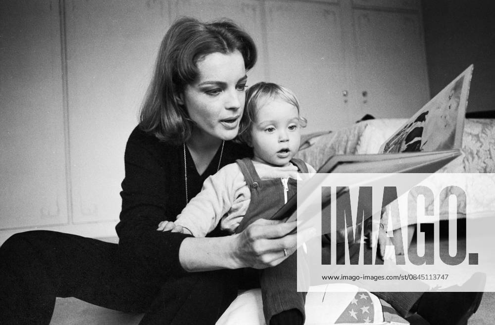 Romy Schneider sits with their Son David at the Floor and scrolls jointly with him in a Picture book, 1968 in Paris Paris France