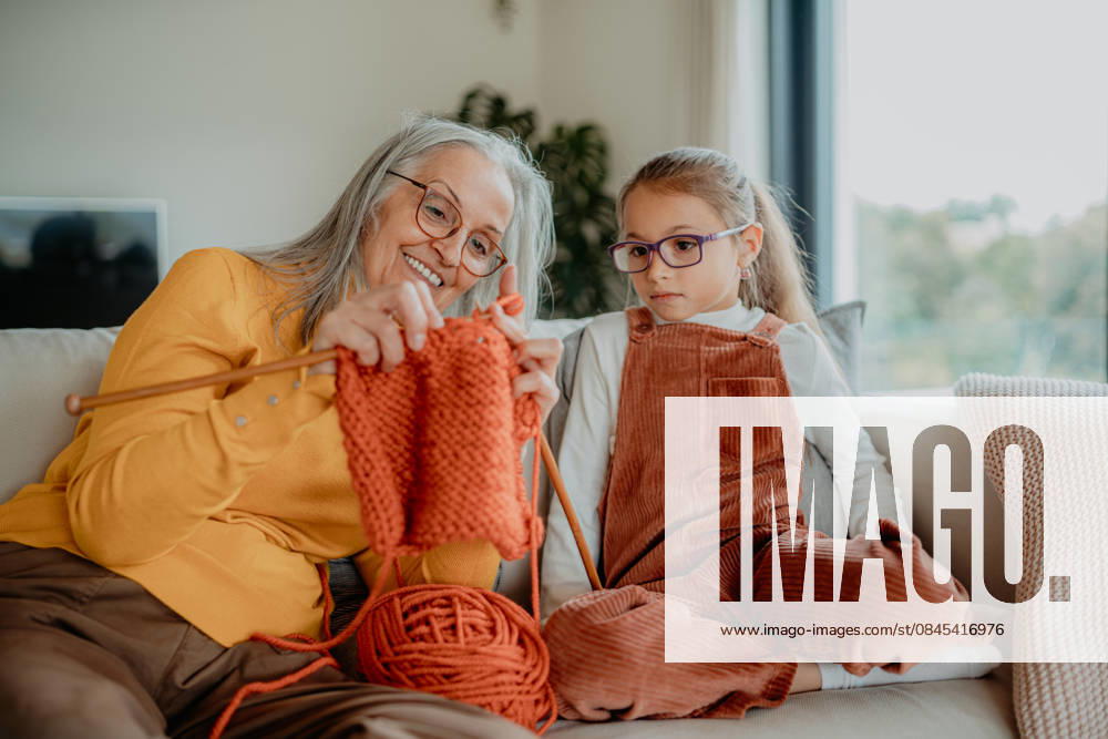 Grandmother teaching young girl how to knit, spending weekend with her. Grandmother teaching young granddaughter how to knit, spending weekend with her. model released
