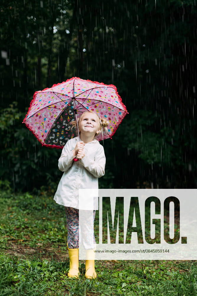IMAGO Creative, Jahreszeit Sommer, Regen, Sommerregen Happy little girl holding a colorful umbrella in the rain McClure, Illinois, United States CR_WEKW260120-1945723-01 ,model released, Symbolfoto