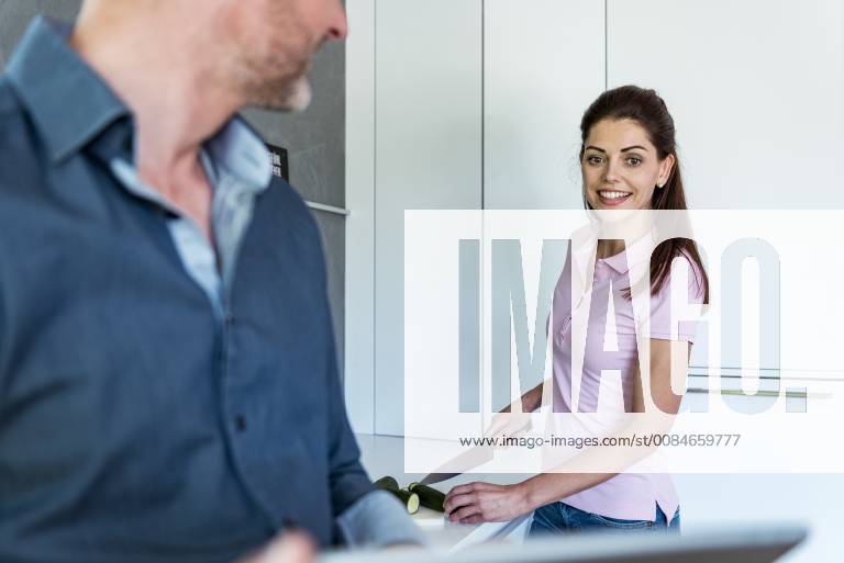 Happy couple in kitchen at home cooking and using a tablet model released Symbolfoto property released DIGF04441