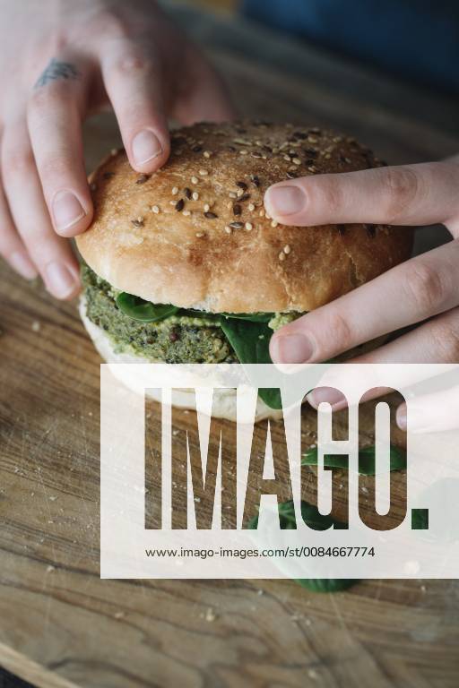 Woman holding homemade vegan burger model released Symbolfoto ALBF00397