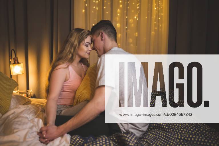 Romantic young couple sitting on bed model released Symbolfoto AWF00050
