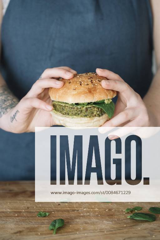 Woman holding homemade vegan burger model released Symbolfoto property released ALBF00396