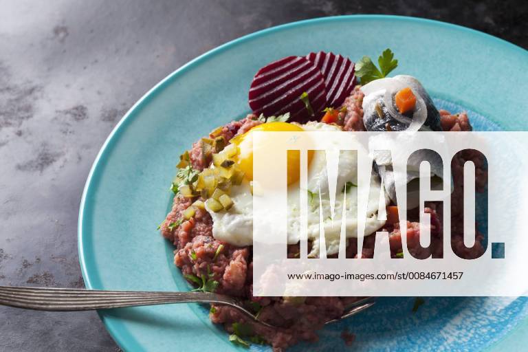 Plate of Labskaus with potatoes, rollmops, pickled gherkin, beetroot and fried egg CSF29200