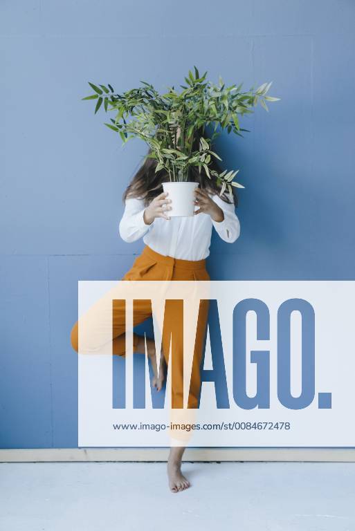Pretty young woman holding potted plant in front of her face model released Symbolfoto property released KNSF03956