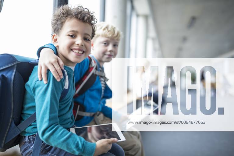 IMAGO Creative: Gesellschaft, Integration Portrait of two smiling schoolgboys with tablet embracing model released Symbolfoto property released WESTF24179
