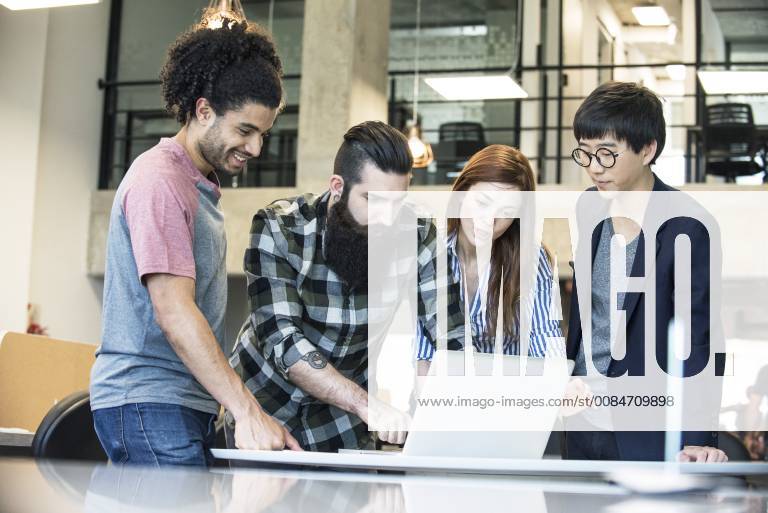 Creative colleagues working together on laptop computer