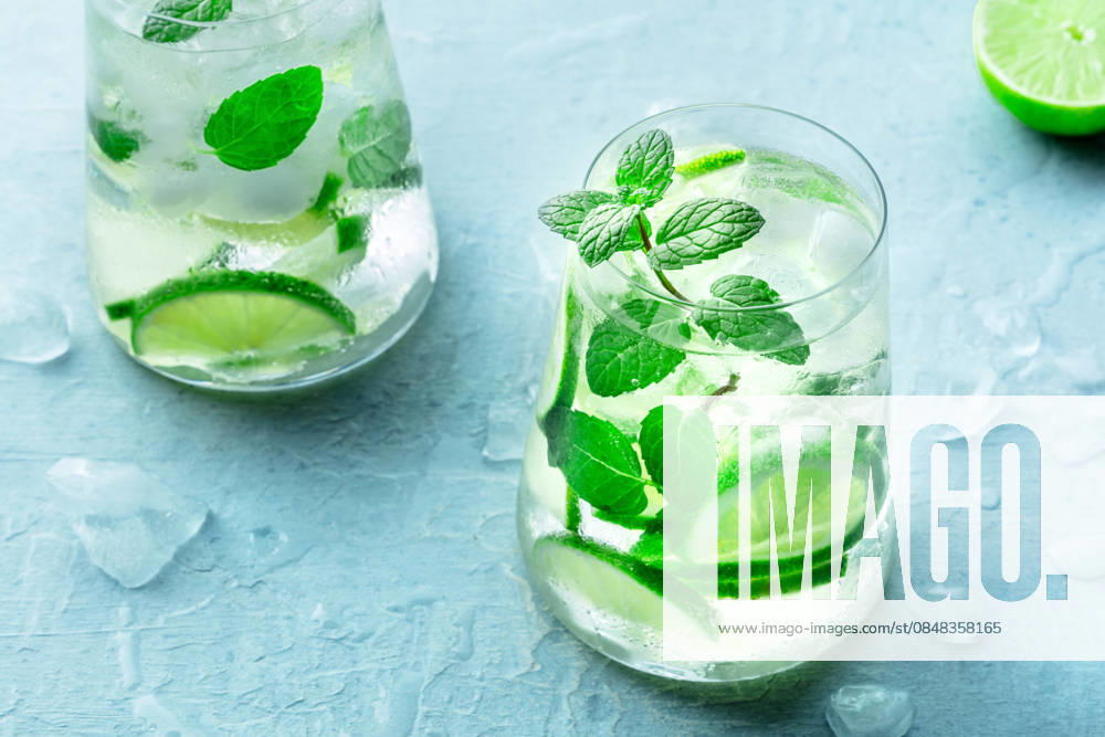 Limettenlimonade oder Limonade in einem Glas mit Limettenscheiben, Minze und Eis Lime lemonade, or limeade, in a glass with lime slices, mint, and ice. Fresh summer Mojito mocktail or cocktail, a close-up (License=RF)