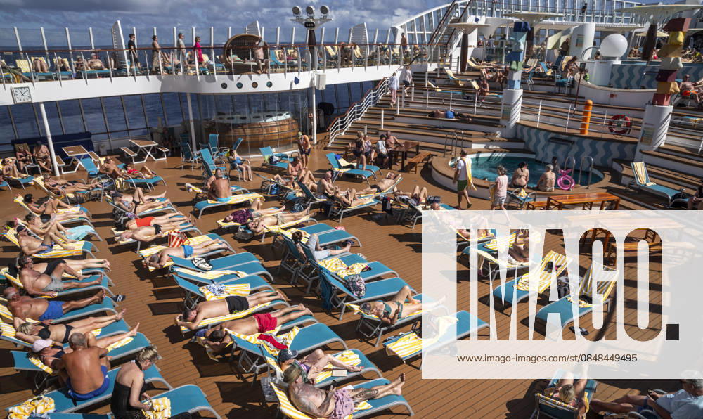 Relaxing on deck on the high seas Passengers on an AIDAblu cruise ship enjoy the voyage through the Caribbean St John s Antigua and Barbuda on the sun deck