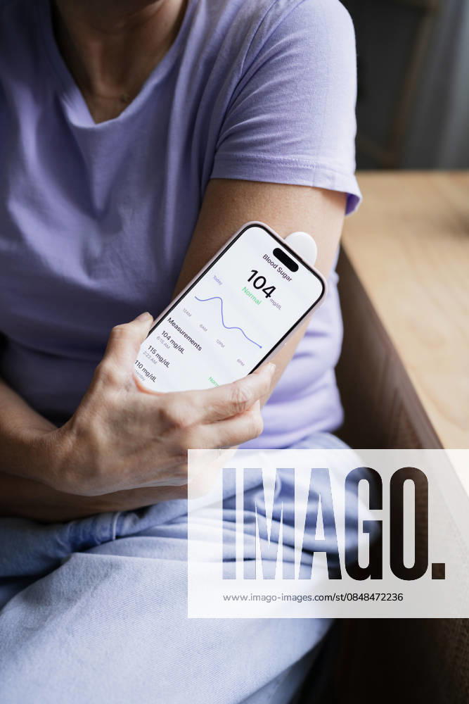 Woman checking blood sugar level with smartphone and glucose monitor model released, Symbolfoto property released, ATSF00315