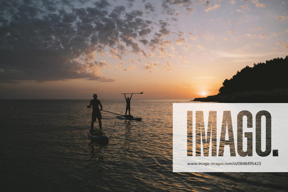 Paddleboarding adventure at sunset with friends by the beach model released, Symbolfoto, NDEF03203
