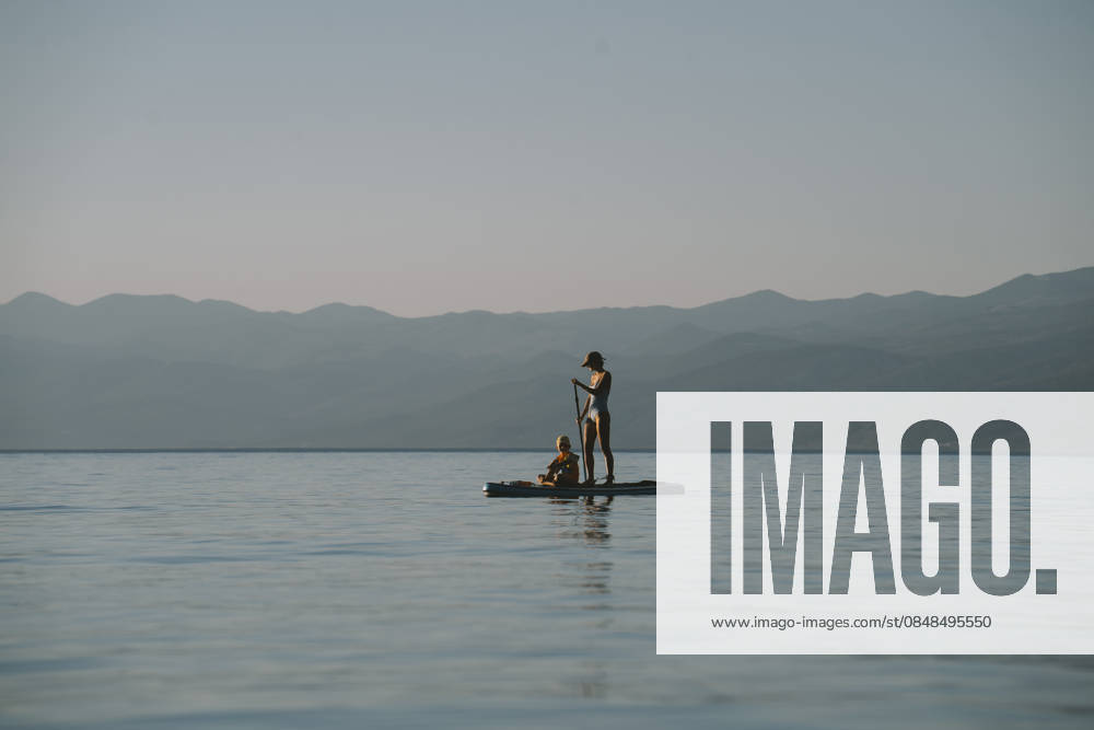 Family paddling on paddleboard against tranquil seascape in summer model released, Symbolfoto, NDEF03221