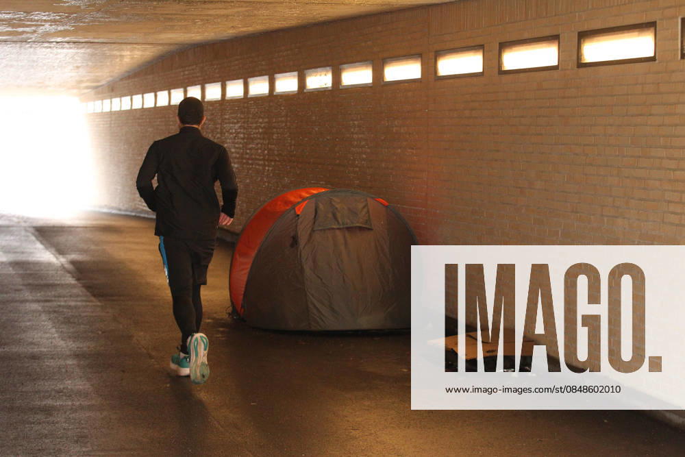 A homeless man lies in a tent under a bridge on Graumannsweg St Georg Hamburg