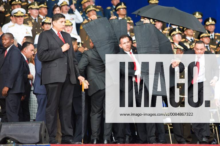 (180804) -- CARACAS, Aug. 4, 2018 () -- Security members protect Venezuelan President Nicolas Maduro after his speech was interrupted in Caracas, Venezuela, on Aug. 4, 2018. A speech by Venezuelan President Nicolas Maduro commemorating the 81st anniversary of the Bolivian National Guard was unexpectedly cut short after he was interrupted on Saturday. () VENEZUELA-CARACAS-MADURO-SPEECH Xinhua