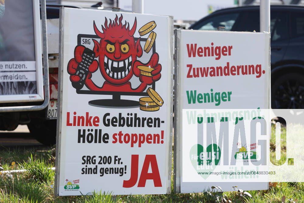 Ruemlang ZH, SWITZERLAND, A Yes poster for the SRG initiative halving initiative on the roadside and an SVP poster Less immigration, less housing shortage