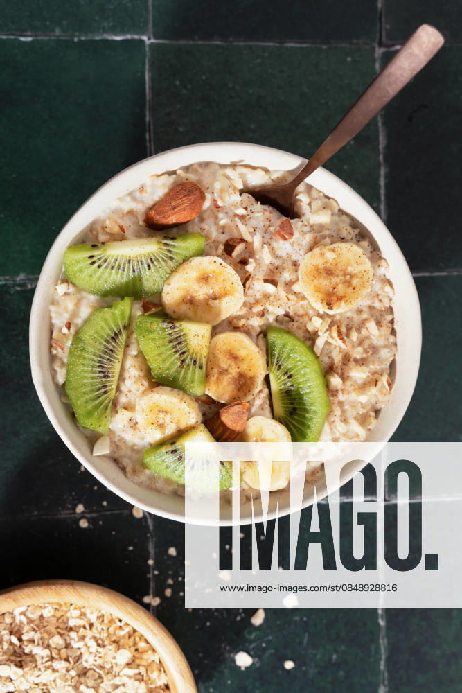 Delicious bowl of oatmeal with kiwi and banana slices A nutritious bowl of oatmeal topped with fresh kiwi slices, ripe banana, and almonds. Perfect for a healthy breakfast, it delivers a good source of fiber and essential nutrients. Model Released MaiderAlvarez_ID33235_1131624_001