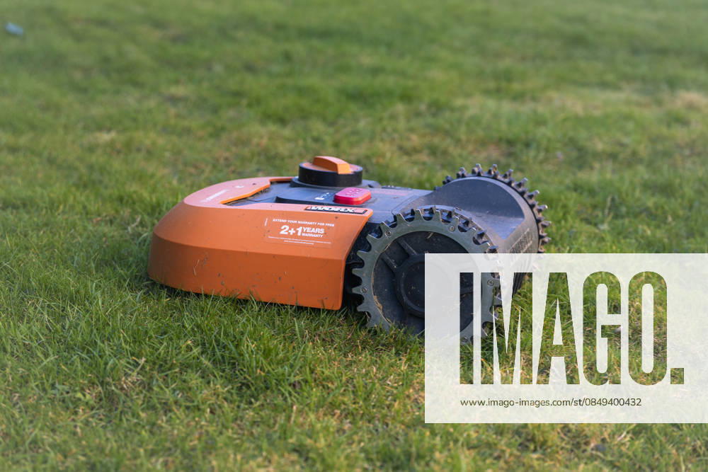 A robot mower stands on a lawn in a garden in Gummersbach Symbolic image on the subject of automated garden maintenance and modern household technology Gummersbach, North Rhine-Westphalia