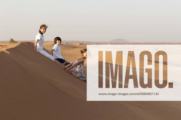 IMAGO Creative, Jahreszeit Sommer, Sommerferien Children sitting on sand dune