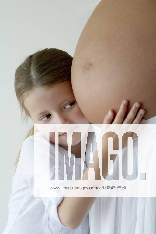 Girl embracing mother s pregnant belly