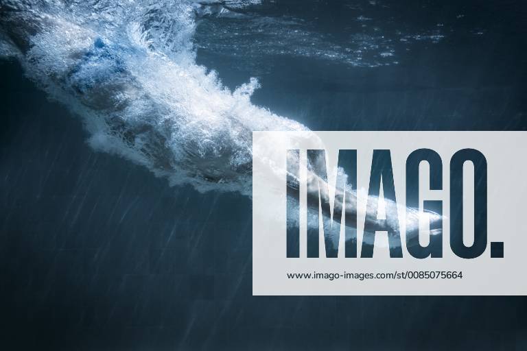 An image of a man diving in a black pool 1032100819